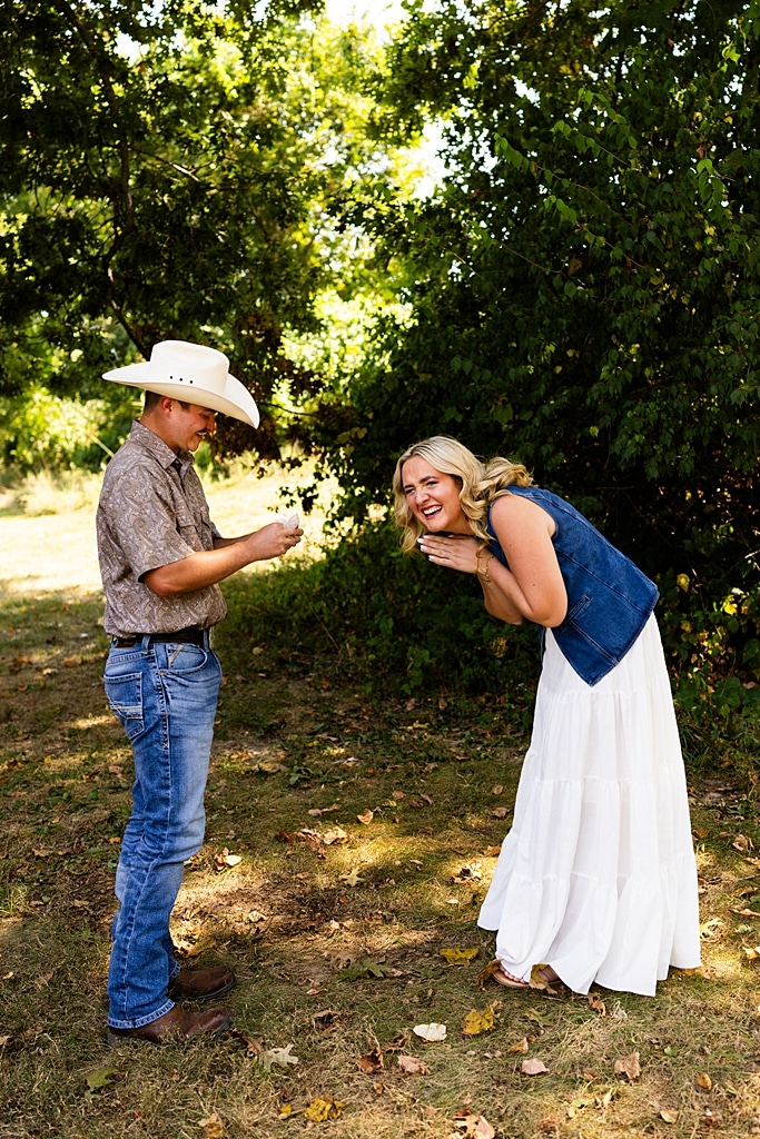 Tyler proposing to Rachel at Chandler Hill Vineyards in Defiance Missouri
Couple standing back to back moments before the surprise proposal
Rachel crying with joy as Tyler kneels during the proposal
Newly engaged couple hugging surrounded by vineyard scenery
Close up of engagement ring in front of rolling vineyard hills